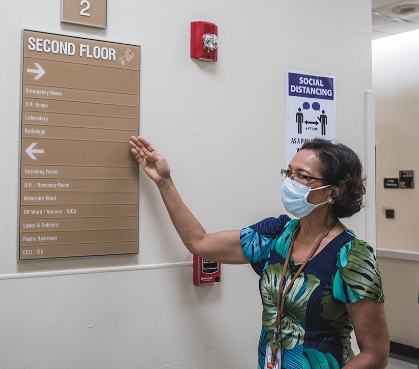 Maria Perez pointing to GMH second floor directory